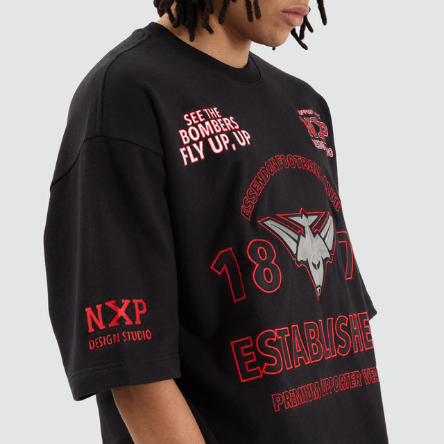 model wears Essendon Bombers AFL Mega Loopback Tee Jet Black T-Shirts Black - image 2