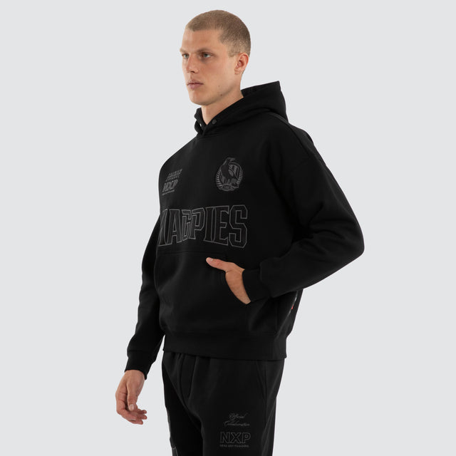 Model wears Collingwood Magpies AFL Persistent Hoodie Jet Black Hoodies Black – image 4