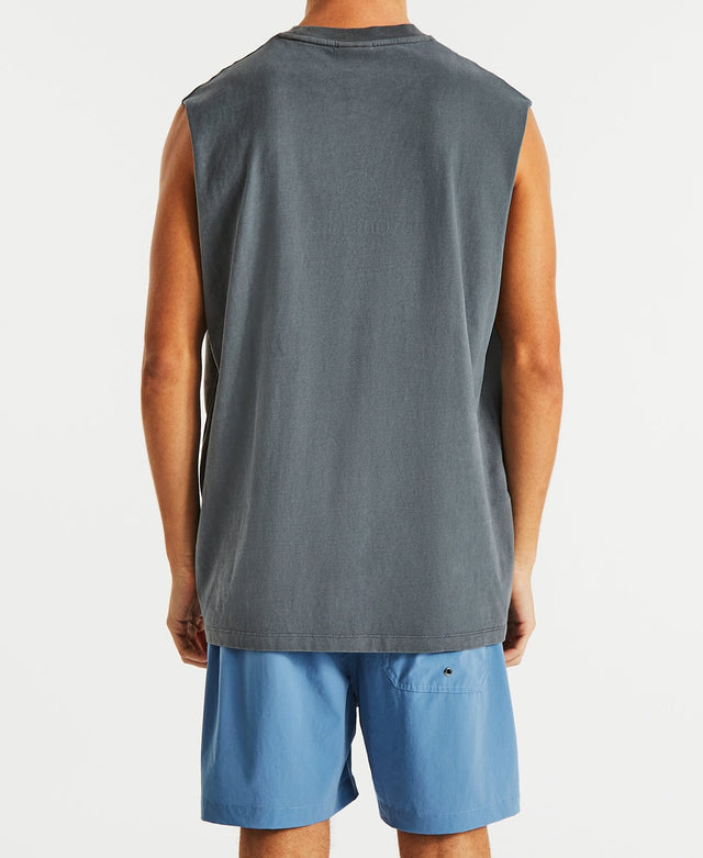 Man wearing relaxed fit, dark grey muscle tee by Nomadic, adorned with a blue and white logo design.